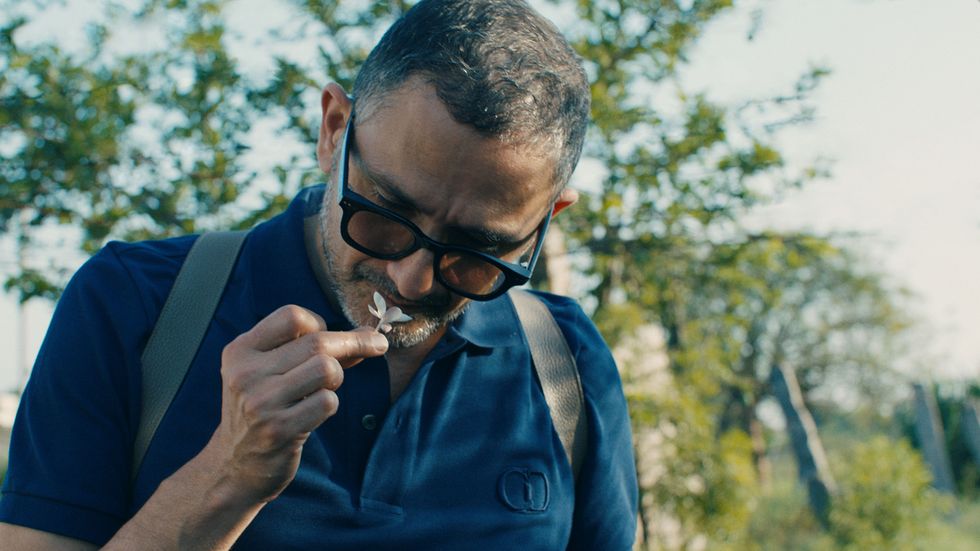 a man smelling a flower